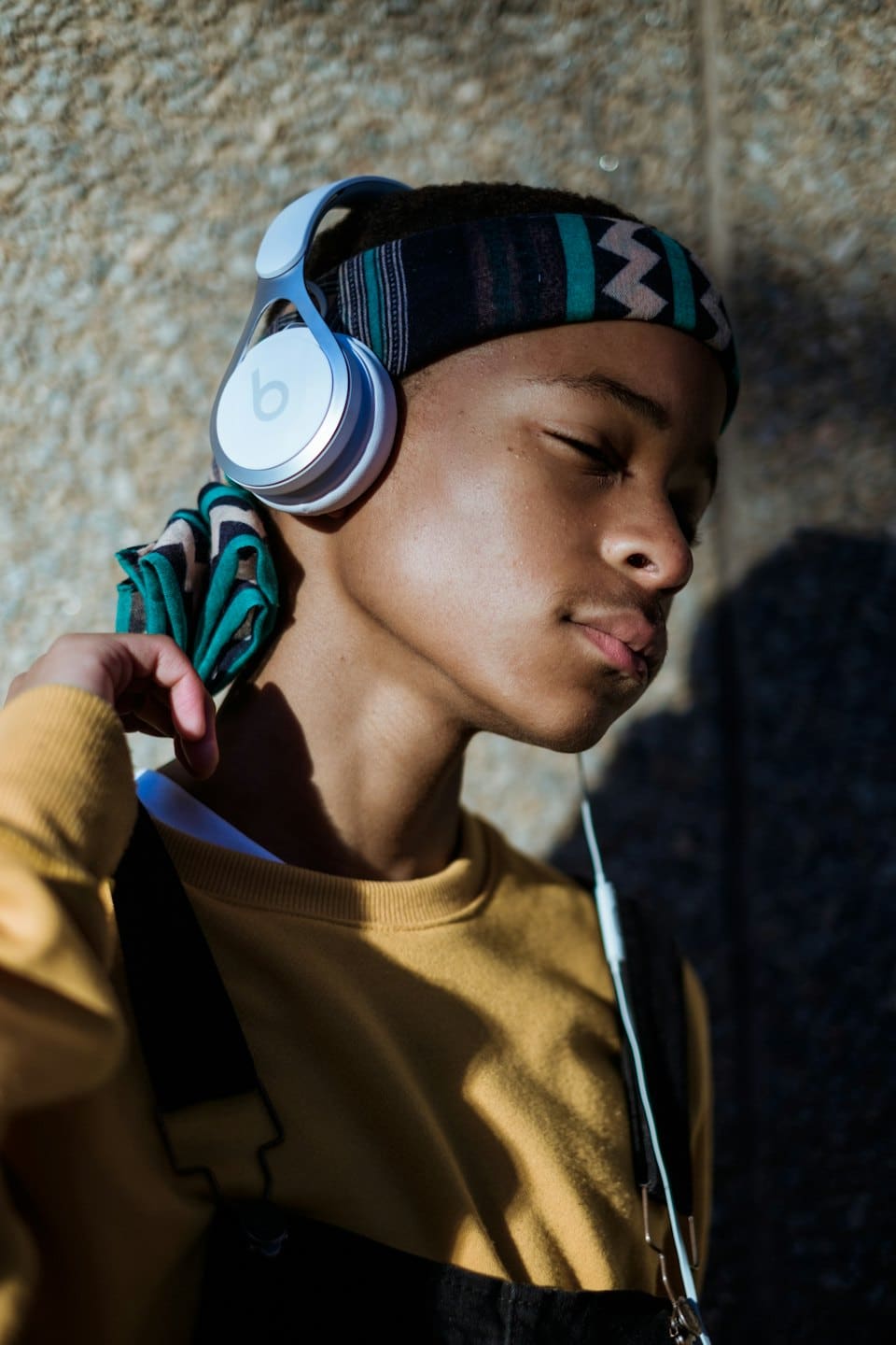 Person with headphones listening to music with eyes closed.